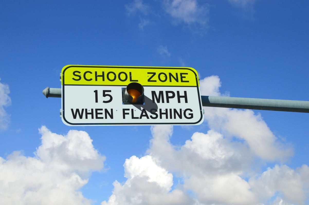 A sign telling drivers to slow down near a school.