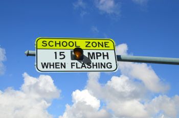 A sign telling drivers to slow down near a school.