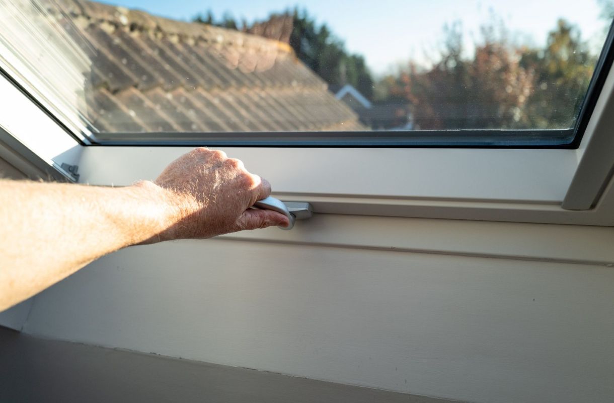 A person shutting a window.