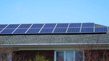 Solar panels installed on the roof of a house on a clear day.