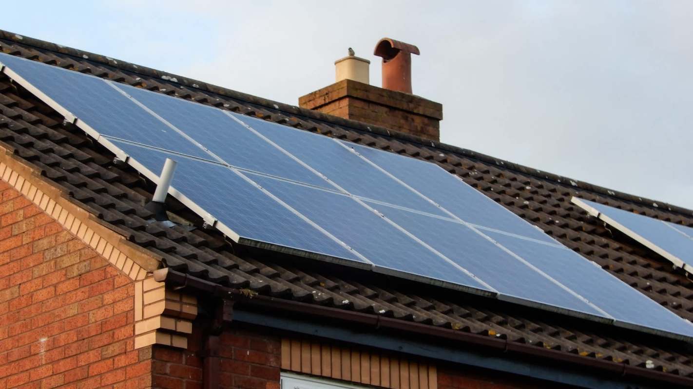 Solar panels installed on a sloped roof of a brick building.