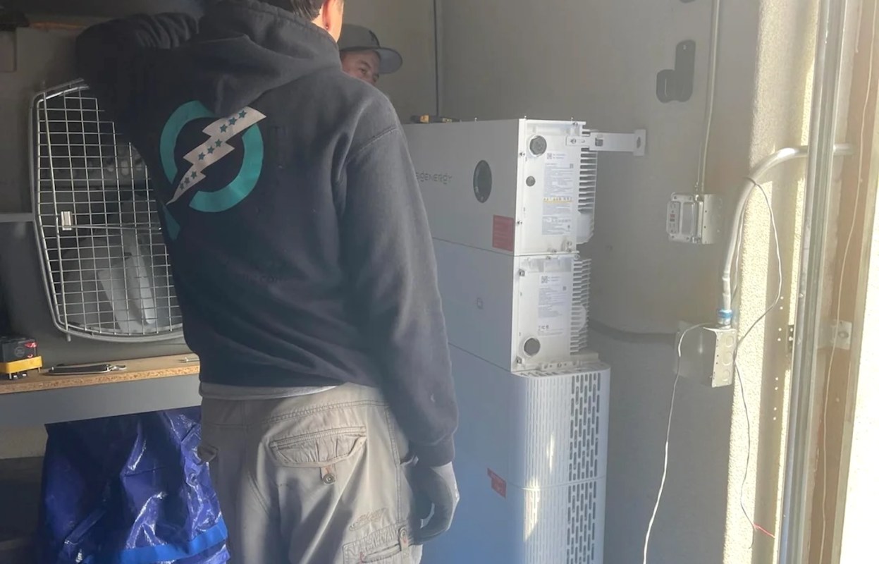 Two people installing a Sigen charger.
