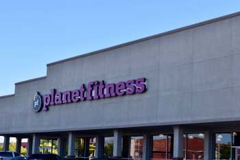 A Planet Fitness gym sign on a building exterior.