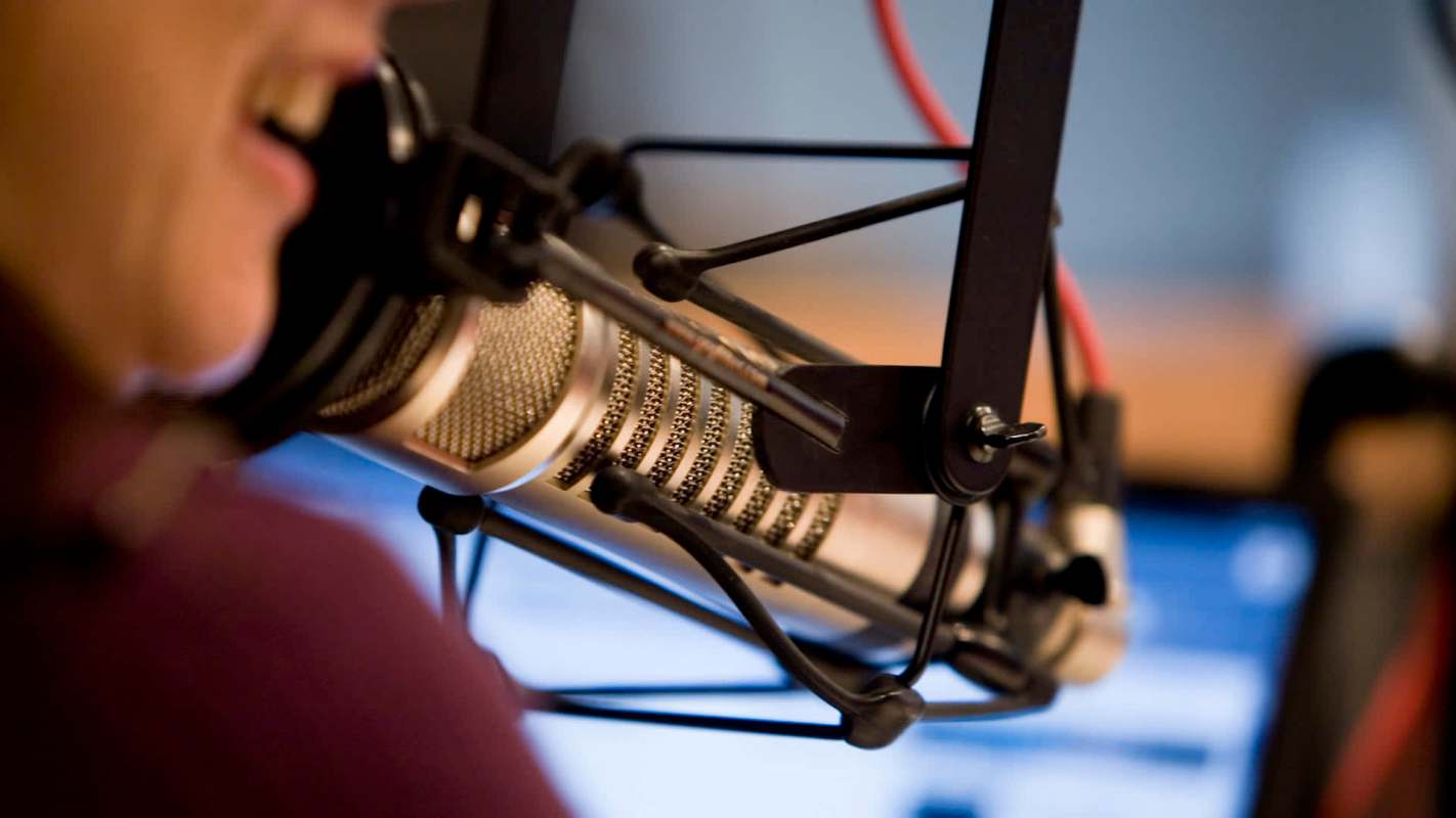 A microphone mounted on a stand with wires visible in the background.