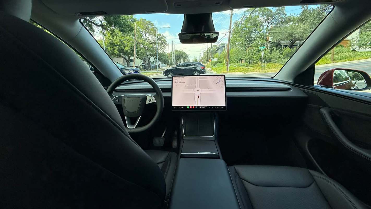 An interior view of a Tesla vehicle showcasing the dashboard and navigation screen.