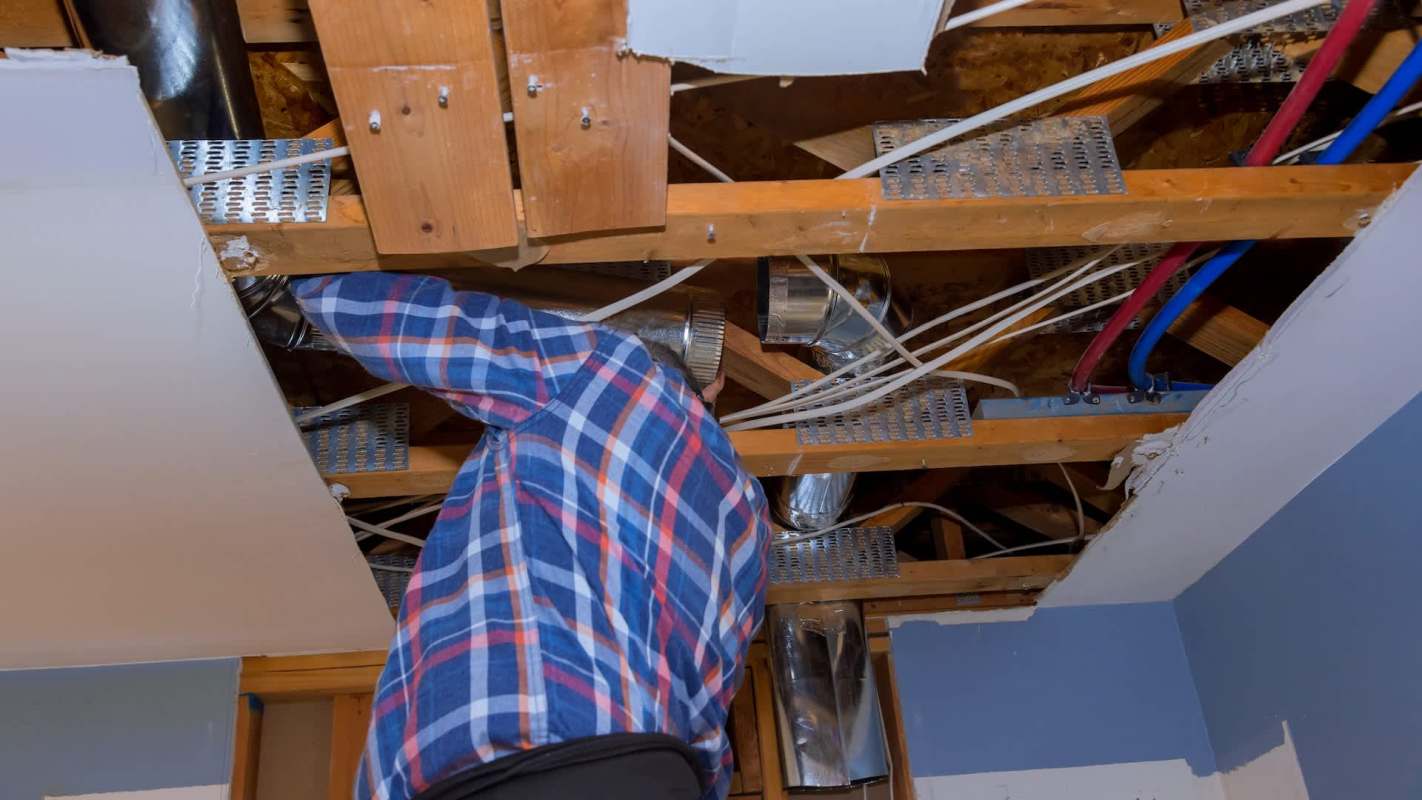 A person looking at ductwork.
