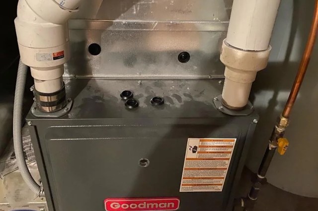 A Goodman furnace with various pipes and valves attached.