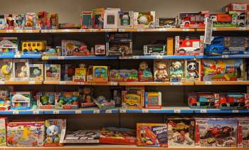 A store shelf filled with various children's toys, including vehicles, plush animals, and educational games.