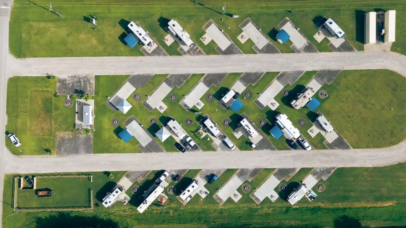 An aerial view of a campground with several RVs parked on designated lots.