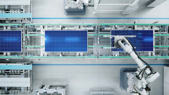 A robotic arm on a solar panel production line.