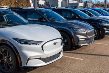 A row of electric vehicles parked in a dealership lot.
