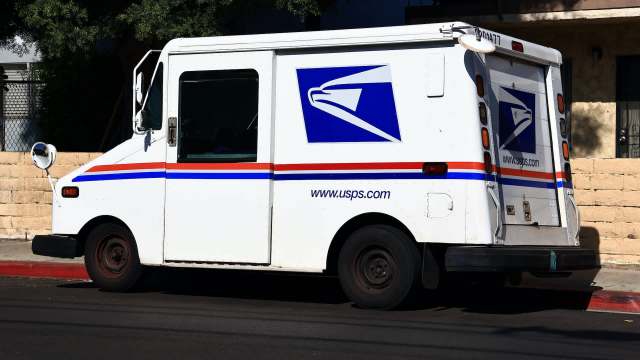 A USPS delivery van parked on the street.