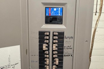 An electrical panel with circuit breakers and labels for various appliances and areas.