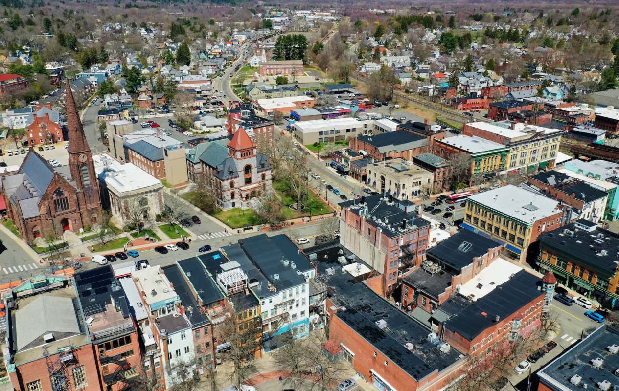 An aerial view of Northampton, Massachusetts, featuring historic buildings, roads, and various parked vehicles.