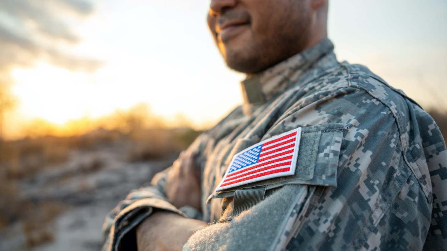 A soldier wearing a military uniform with an American flag patch.