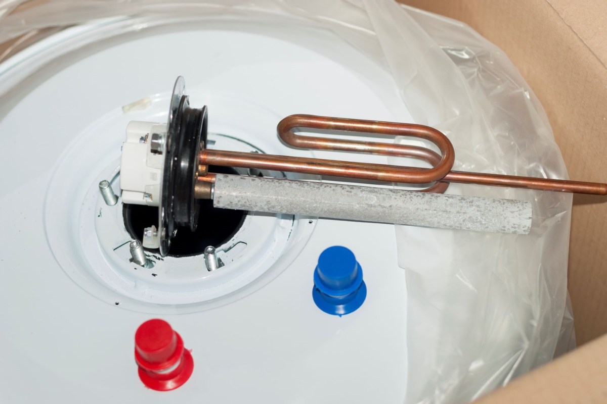A water heater tank with heating elements and fittings visible.