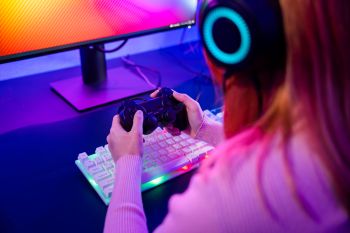 A young person gaming at a computer.
