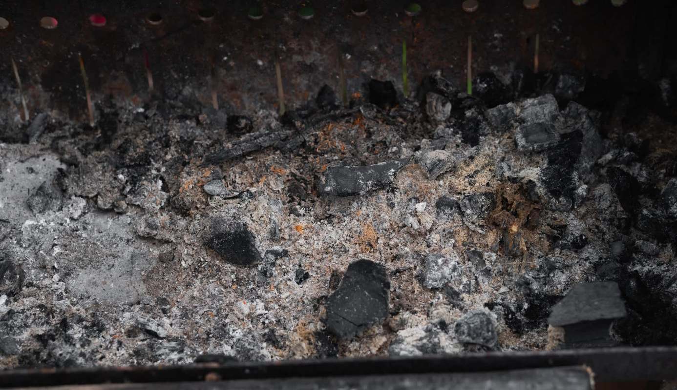 Ash and charcoal remnants in a grill.