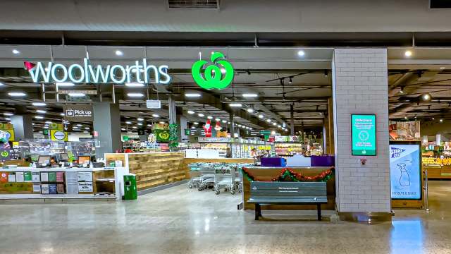 A Woolworths supermarket interior featuring shopping carts, displays, and a sign for Quiet Hour.