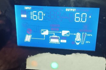 A digital display showing input and output values for charging, including voltage and current readings.